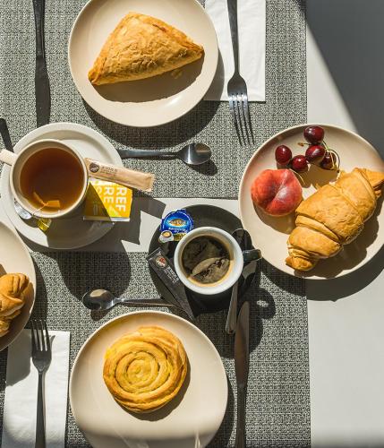 a table with plates of pastries and a cup of coffee at Füred Centrum Panzió in Balatonfüred
