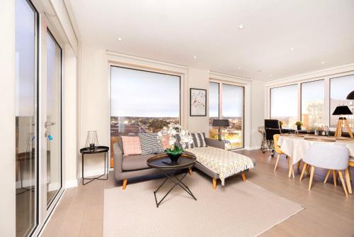 uma sala de estar com um sofá e uma mesa em Stunning 2BR Apt Bromley Views Terrace em Bromley