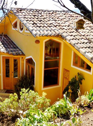 a small yellow house with a roof at La Casa de las Aves - Architect's House/ Amazing view & garden in San Cristóbal de Las Casas
