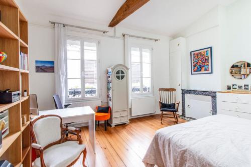 Un dormitorio con una cama y un escritorio y sillas. en Merveille des Chartrons, en Burdeos