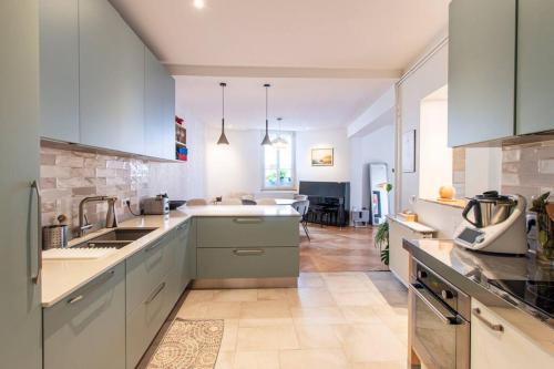 une cuisine avec des armoires blanches et un comptoir dans l'établissement Merveille des Chartrons, à Bordeaux