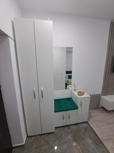 Baño blanco con lavabo y espejo en Anne Studio, en Onești