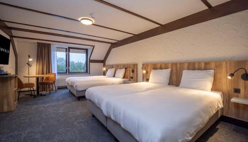 um quarto de hotel com duas camas e uma mesa em Fletcher Hotel-Restaurant de Witte Brug em Lekkerkerk