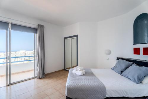 une chambre avec un grand lit et une grande fenêtre dans l'établissement 418 Paranoramic View By Paramount Holidays, à Adeje