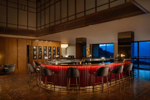 a bar in a hotel lobby with stools at Taj Guras Kutir Resort & Spa, Gangtok in Gangtok