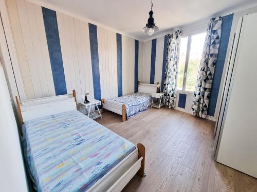 - une chambre avec 2 lits et des rayures bleues et blanches dans l'établissement Brice Marine - T4 climatisé en centre-ville, au Lavandou