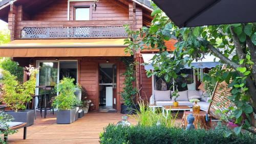 Casa con terraza de madera con macetas en Dans un parc privatif arboré, en Réau