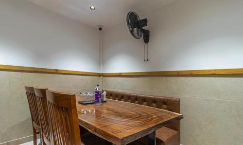 a wooden table with chairs and a clock on the wall at Treebo Trend Tiba in Bangalore