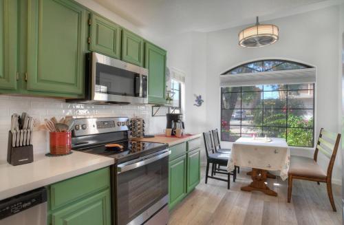 uma cozinha com armários verdes e uma mesa com cadeiras em Fountain Hills Bungalow West em Fountain Hills