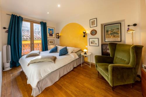 une chambre avec un grand lit et une chaise verte dans l'établissement Spacious and bright flat close to the beach : heart of old Nice, à Nice