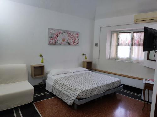 a white room with a bed and a window at Albergo Caffaro in Genova