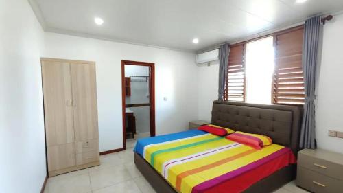 a bedroom with a bed with a colorful blanket at Modern Master bedroom B in Nadi