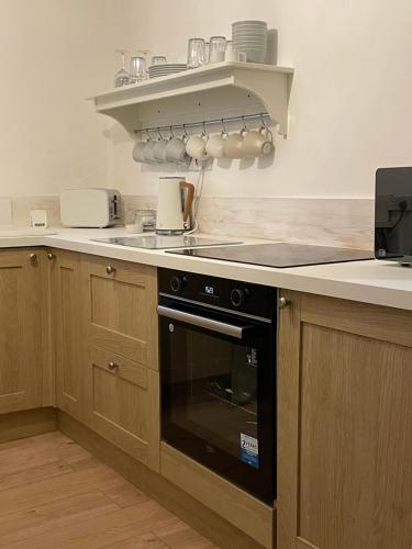 a kitchen with a stove and a counter top at Shakespeare’s Nest in Prescot