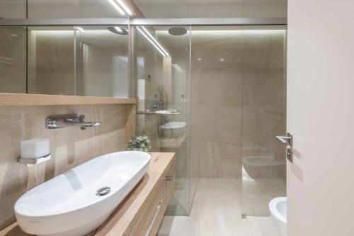 ein Badezimmer mit einem weißen Waschbecken und einer Dusche in der Unterkunft Villa Brzet - Luxury Boutique Apartments in Omiš