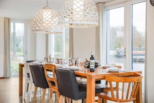 una sala da pranzo con tavolo e sedie in legno di Summio Waterpark De Bloemert a Zuidlaren