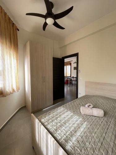 - une chambre avec un lit et un ventilateur de plafond dans l'établissement Belvedere 2, à Dráma