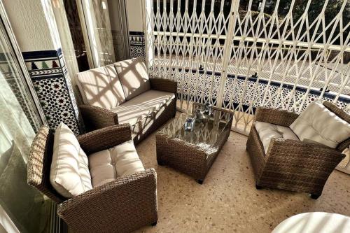 薩洛的住宿－AZUL 2 bedroom apartment in Salou Tarragona，阳台配有藤椅和沙发。