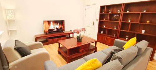 a living room with a couch and a table at Aloe Villa in Harrow