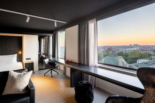 una camera con scrivania e ampia finestra di nhow Brussels Bloom a Bruxelles
