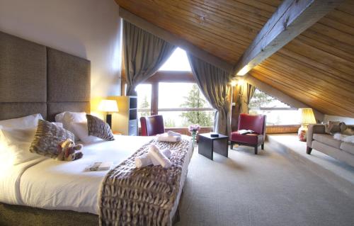 Cette chambre comprend un lit et une grande fenêtre. dans l'établissement Odalys Hotel New Solarium, à Courchevel