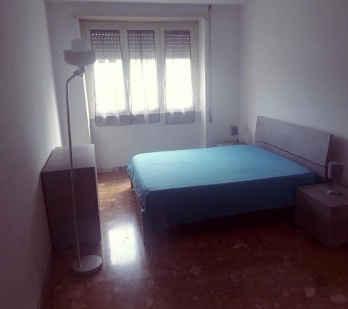 una camera con un letto blu e una finestra di Camera matrimoniale vicino a San Pietro a Roma