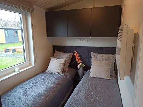 two beds in a tiny house with a window at Tiny Haus 21 in Nabburg