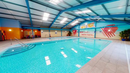 a large swimming pool in a large room at Camping Pods, Marlie Holiday Park in New Romney