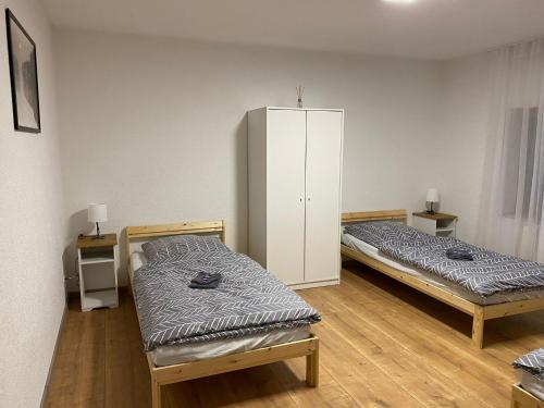 Habitación con 2 camas y armario blanco en Ferienwohnung Schwabenheim an der Selz en Schwabenheim