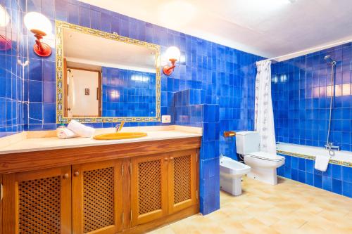 een blauw betegelde badkamer met een wastafel en een toilet bij Son Suau Vell by Mallorca House Rent in Felanitx
