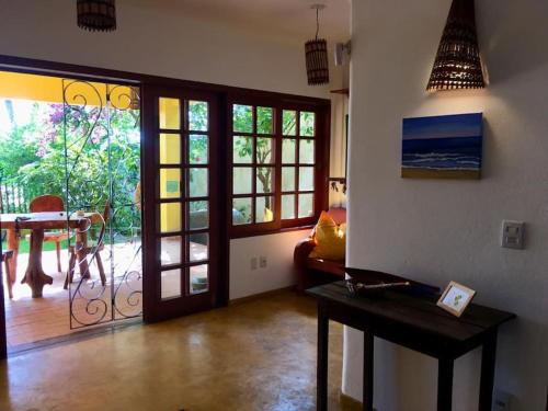 uma sala de estar com uma porta que abre para um pátio em Apartamento com jardím e vista por rio, farol e mar em Itacaré