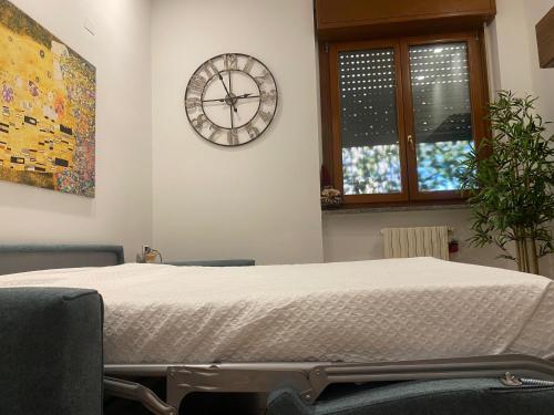Casa Sofia Lissone في ليسّوني: سرير في غرفة مع ساعة على الحائط