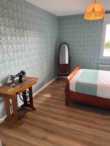 1 dormitorio con cama, lavabo y espejo en Appartement Thème Années 20, proche du Puy Du Fou, en Pouzauges