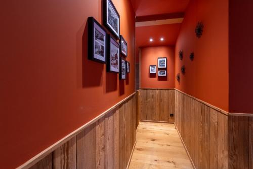 a hallway with orange walls and a wooden floor at Chalet Jardin Alpin Valberg in Péone