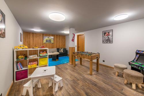 a living room with a table and a play room at Chalet Jardin Alpin Valberg in Péone