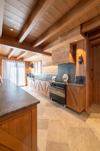 a large kitchen with wooden walls and wooden counters at Chalet Jardin Alpin Valberg in Péone