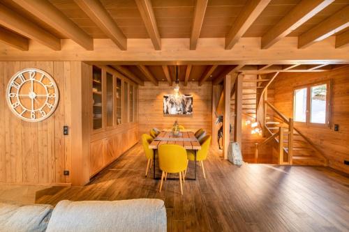 a dining room with a table and yellow chairs at Chalet Jardin Alpin Valberg in Péone