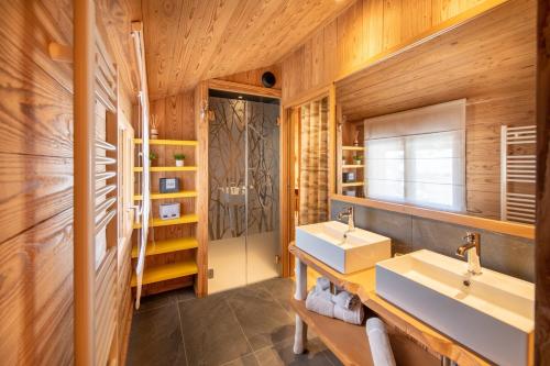 a bathroom with two sinks and wooden walls at Chalet Jardin Alpin Valberg in Péone