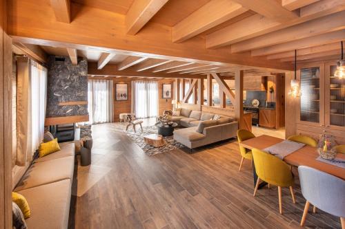 a living room with wooden ceilings and a table and chairs at Chalet Jardin Alpin Valberg in Péone