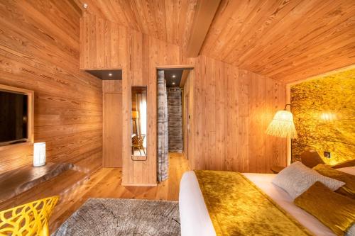 a bedroom with wooden walls and a large bed at Chalet Jardin Alpin Valberg in Péone