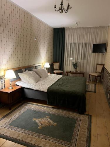 Saku Mõis & Saku Manor في Saku: غرفة نوم مع سرير وغرفة معيشة