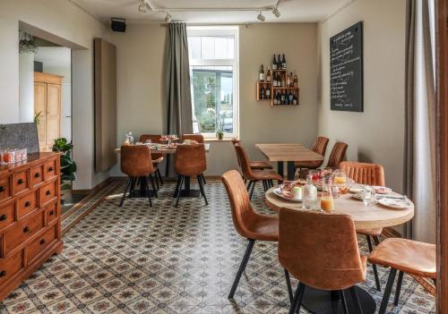a restaurant with tables and chairs in a room at LE MANOIR DE LA VALETTE in Florennes