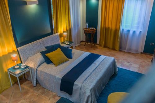 a bedroom with a large bed with blue and yellow pillows at Villa Durante in Cagli