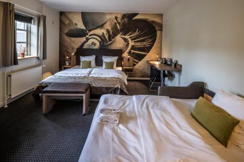 a bedroom with two beds and a painting on the wall at The Lodge Billund in Billund