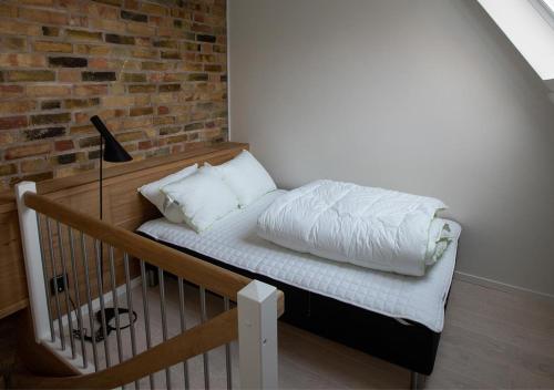 een bed in een kamer met een bakstenen muur bij Hotell Havsporten in Karlholmsbruk