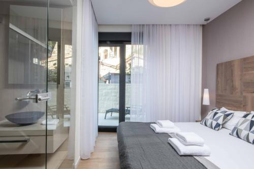 a bedroom with a large bed and a bathroom at Villa Brzet - Luxury Boutique Apartments in Omiš