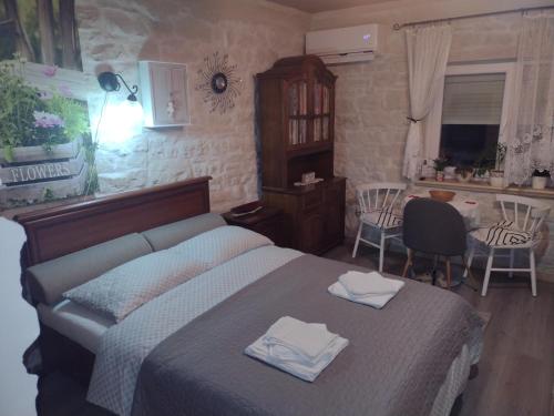 a bedroom with a bed with two towels on it at Stone house next to Cluj-Napoca in Dezmir