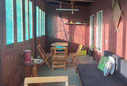 a porch of a house with chairs and a table at Ribeirinhos Hostel in Maués