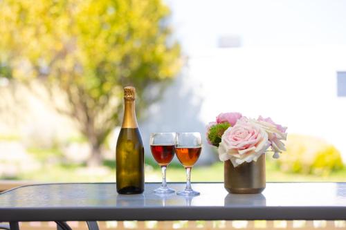 a bottle of wine and two glasses on a table at Hallett Cove House 6Bed 3Bath Full Kitchen Fast Wifi 5TV Netflix Espresso-Perfect for large families in Halletts Cove