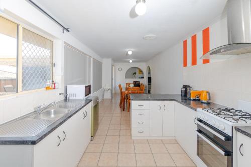 a kitchen with a sink and a stove top oven at Hallett Cove House 6Bed 3Bath Full Kitchen Fast Wifi 5TV Netflix Espresso-Perfect for large families in Halletts Cove