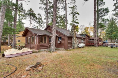 a cabin in the woods with a boat in the yard at Rustic Bemidji Cabin with Boat and Lake Access! in Bemidji